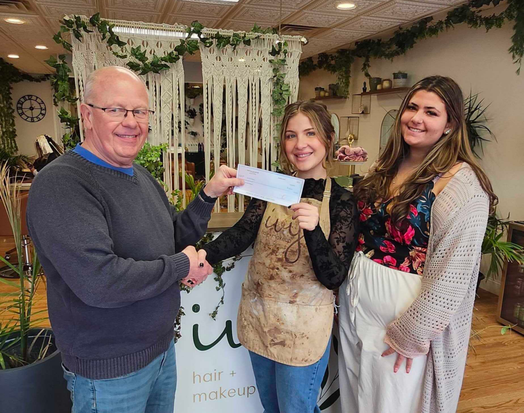 Ivy Hair and Makeup Boutique accepts their award check for best Holiday Windows in Downtown Denville